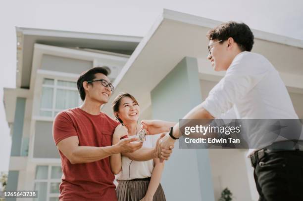 an asian chinese family moving into new house and received the house key from real estate agent - buy house stock pictures, royalty-free photos & images