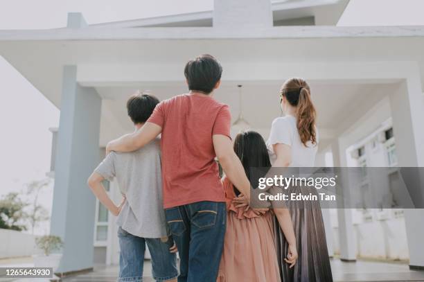 una familia china asiática que se muda a la nueva casa admirando su casa - family in front of home fotografías e imágenes de stock