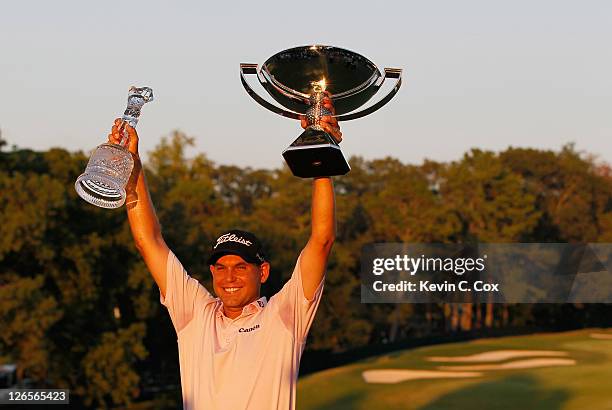 Bill Haas poses on the 18th green after winning won both the TOUR Championship and the FedExCup after the final round of the TOUR Championship at...