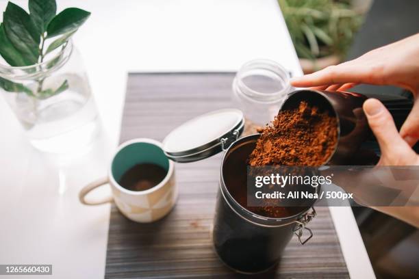 cropped hands pouring ground coffee into reusable container, lleida, spain - coffee powder bildbanksfoton och bilder