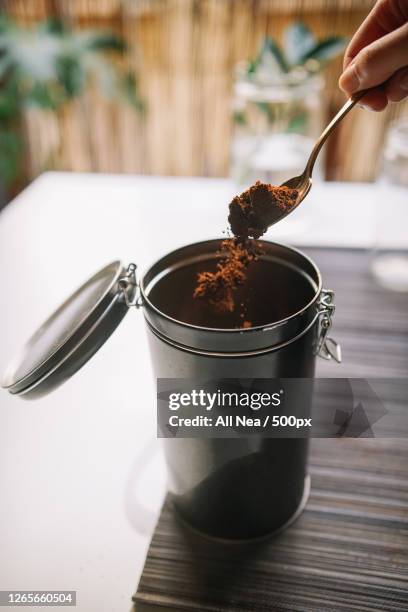 cropped hand of woman scooping ground coffee from reusable container, lleida, spain - coffee powder bildbanksfoton och bilder