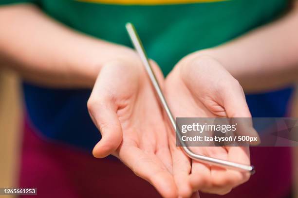midsection of woman holding stainless steel straw, inwad, poland - metal straw stock pictures, royalty-free photos & images