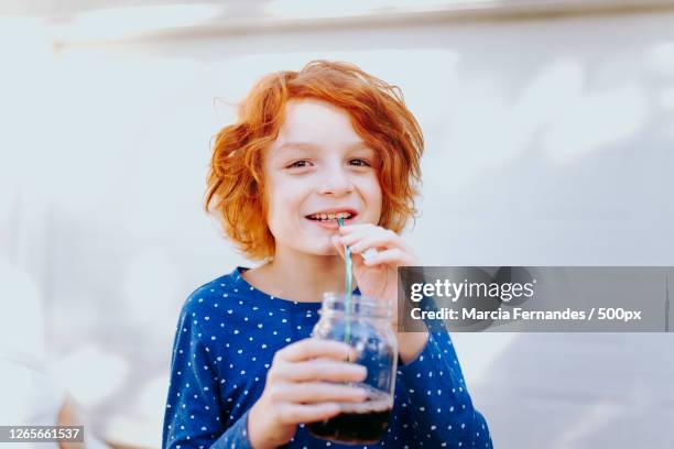 smiling young boy drinking from eco-friendly glass cup while standing against wall, victoria, canada - metal straw stock pictures, royalty-free photos & images