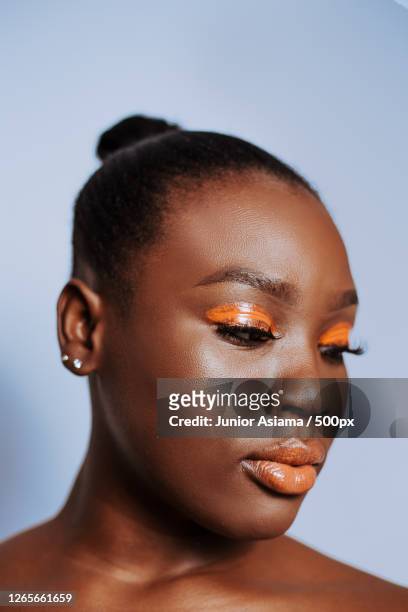 beauty portrait of black adult woman with orange eyeshadow - eyeshadow foto e immagini stock