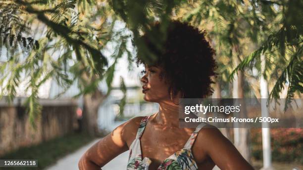 side view of young black woman with natural hair, on the street, barranquilla, colombia - barranquilla fotografías e imágenes de stock