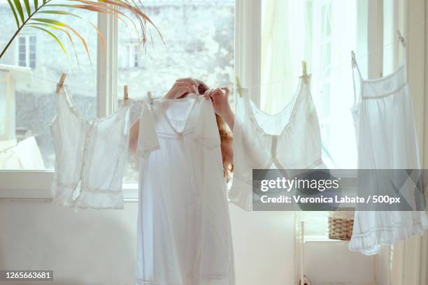 teenage girl hanging clothes in home, cagliari, italy - washing up stock pictures, royalty-free photos & images