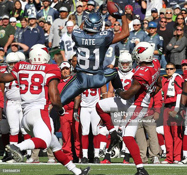 Wide receiver Golden Tate of the Seattle Seahawks makes a leaping catch against Patrick Peterson and Daryl Washington of the Arizona Cardinals at...