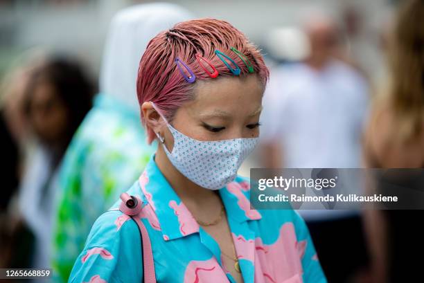 Guest with pink hair wearing colorful pants and shirt, pink bag and face mask outside Soulland during Copenhagen fashion week SS21 on August 10, 2020...