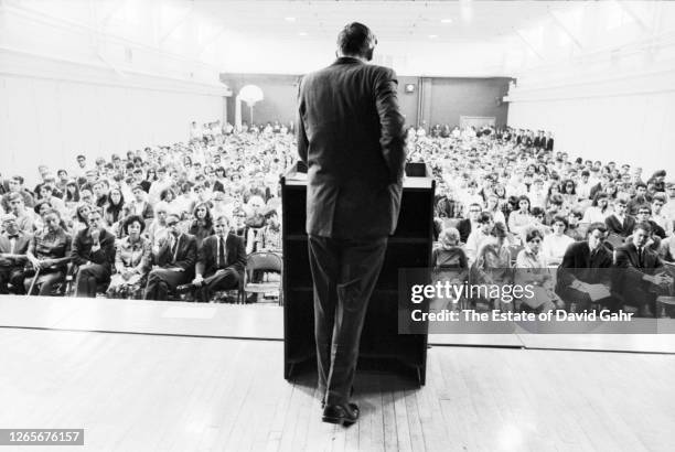 American public intellectual, commentator, and author William Frank Buckley, Jr. Stands on stage, back to the camera, giving a speech to a large...