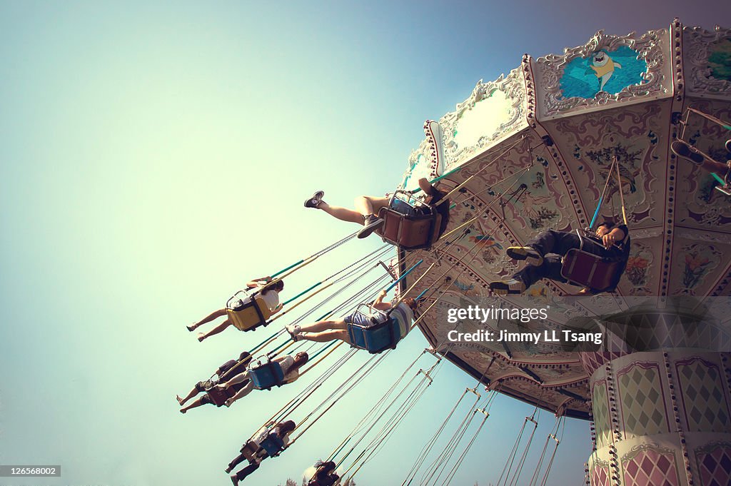 People playing swing carousel in amusement park