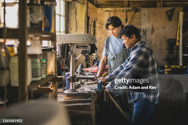 father teaching son in workshop - filipino family stock pictures, royalty-free photos & images