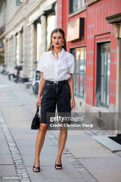Guest is seen wearing white blouse, black Hermes black shorts outside Selected during Copenhagen Fashion Week Spring/Summer 2021 on August 12, 2020...