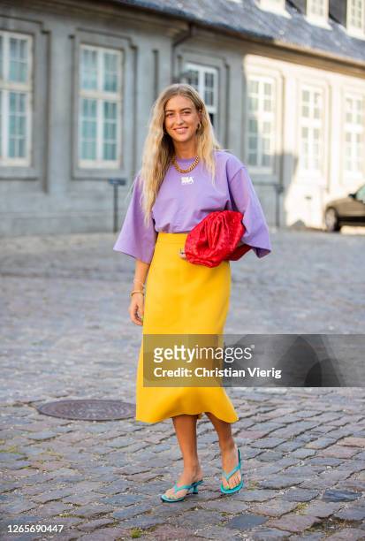 Emili Sindlev is seen wearing yellow skirt, purple tshirt, red Bottega Veneta bag, sand outside Selected during Copenhagen Fashion Week Spring/Summer...