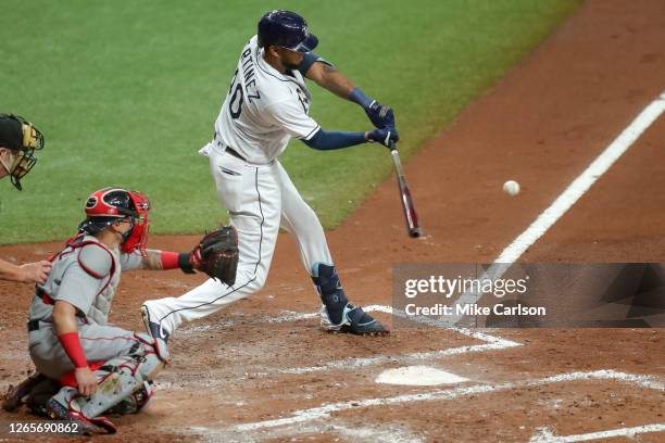 Jose Martinez of the Tampa Bay Rays hits in front of Christian Vazquez of the Boston Red Sox in the fourth inning of a baseball game at Tropicana...