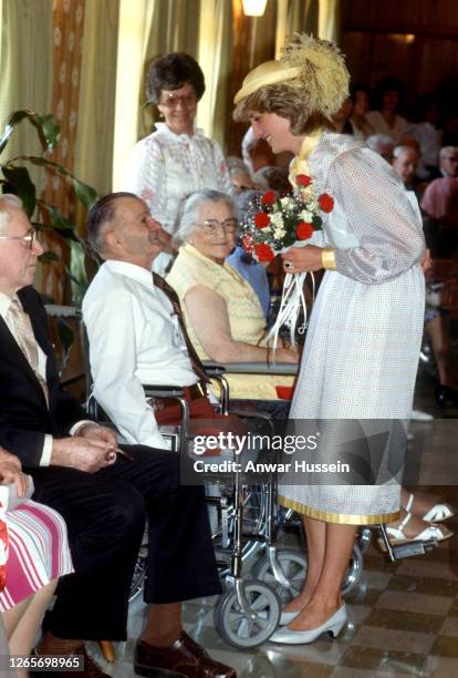 Diana, Princess of Wales, wearing a yellow hat with ostrich feathers, during a visit to a care home for the elderly in Summerside on June 28, 1983 in...