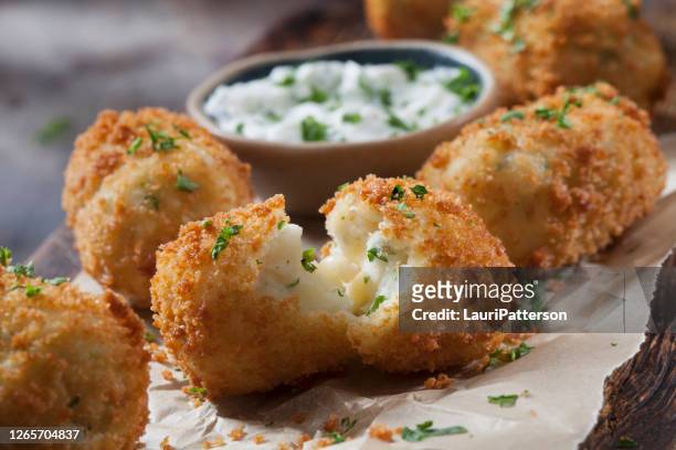 romige aardappelappelkroketten met kaas en zure roomdip - gebakken in de pan stockfoto's en -beelden