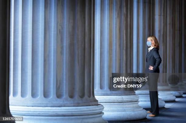 l’homme portant le masque protecteur de visage se tient parmi la rangée des colonnes grecques - pandemie photos et images de collection