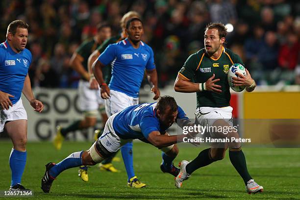 Tinus Du Plessis of Namibia dives on for the tackle on Francois Hougaard of South Africa during the IRB 2011 Rugby World Cup Pool B match between...