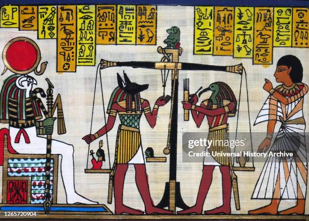 Contemporary papyrus depicting the ancient Egyptian gods Anubis and Thoth weighing of the heart for a deceased pharaoh. Ra Harachte looks on.
