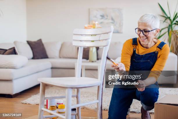 mujer mayor coloreando una silla vieja y disfrutando en casa - incompleto fotografías e imágenes de stock