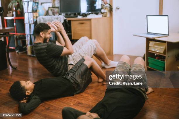 Meninos se exercitam com o pai usando vídeo de streaming