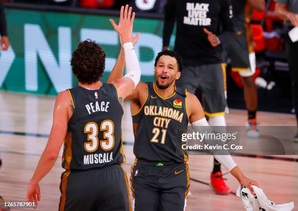 Andre Roberson celebrates with Mike Muscala of the Oklahoma City Thunder after Muscala hit a three point basket against the Miami Heat during the...