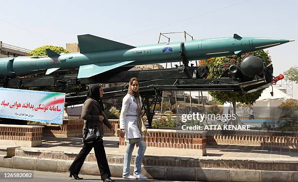 Iranian women walk past a Sayyad-1 surface-to-air missile, displayed at a square in southern Tehran, on September 26, 2011 to mark the "Sacred...