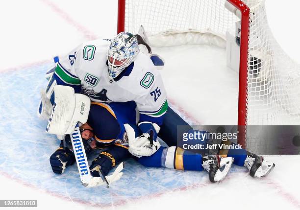 Troy Brouwer of the St. Louis Blues ends up under Jacob Markstrom of the Vancouver Canucks during the second period in Game One of the Western...