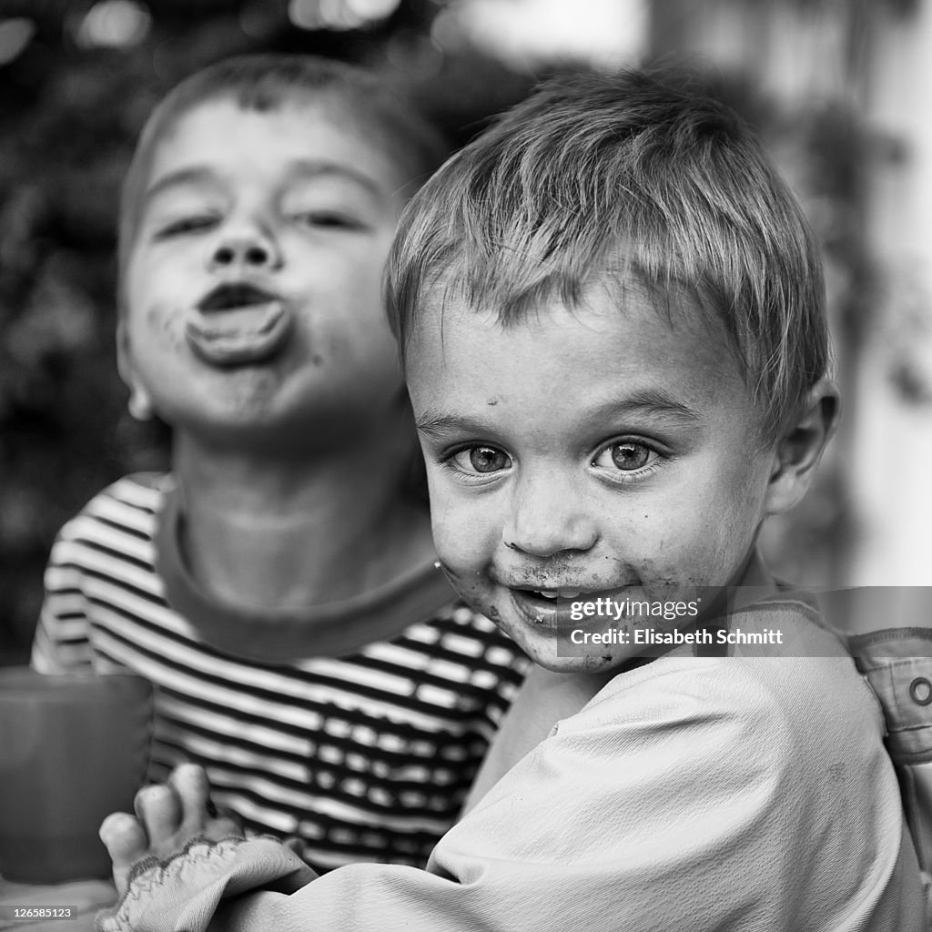 Two young boys, one smiling, one showing tongue