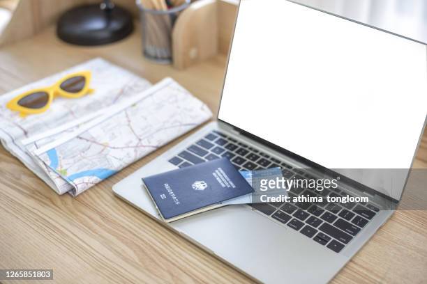 travel planning. travel concept. vacation planning. passport on a laptop, glasses, map. view from above. - booking vacations stock pictures, royalty-free photos & images