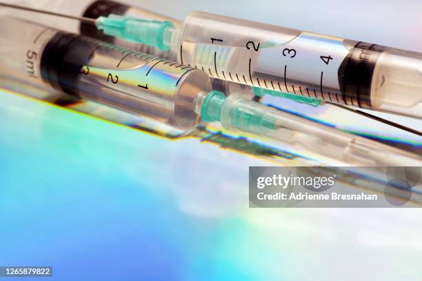 syringes on holographic background - blue injection pen stock pictures, royalty-free photos & images
