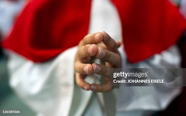 An altar server prays during a mass given by Pope Benedict XVI at the Olympic stadium in Berlin on September 22 on the first day of his first state...