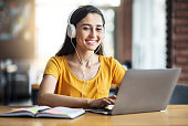 Smiling arab girl with headset studying online, using laptop
