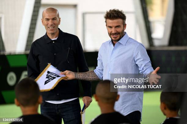 Former footballers Zinedine Zidane and David Beckham speak to children during a promotional day with gaming brand EA Sports at the Z5 sports complex...