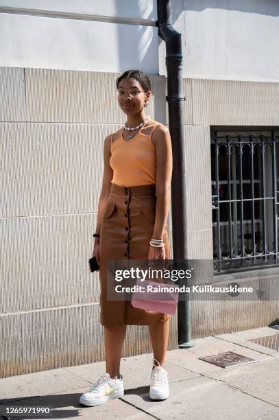 Sara Flaaen Licius outside MFPEN wearing yellow top, brown leather skirt, white sneakers, pink bag and yellow glasses during Copenhagen fashion week...