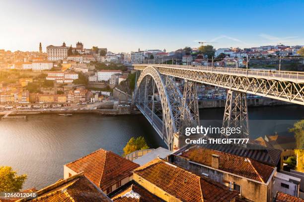 the ribeira or riverside in porto with luís i bridge at sunset - oporto stockfoto's en -beelden