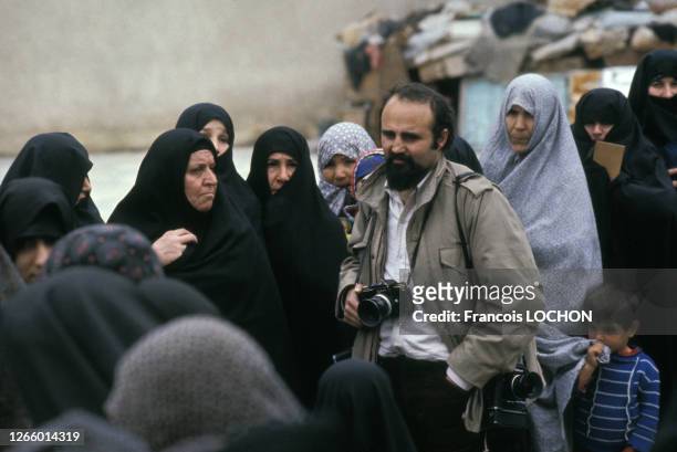 Le photographe franco-iranien Abbas Attar entouré de femmes voilées en Iran, circa 1990.