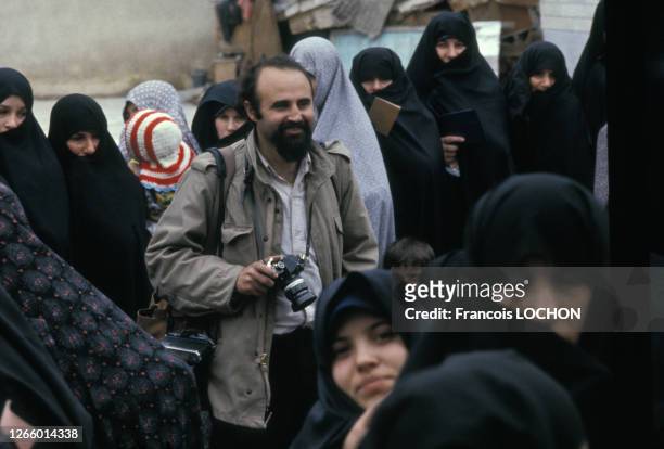 Le photographe franco-iranien Abbas Attar entouré de femmes voilées en Iran, circa 1990.