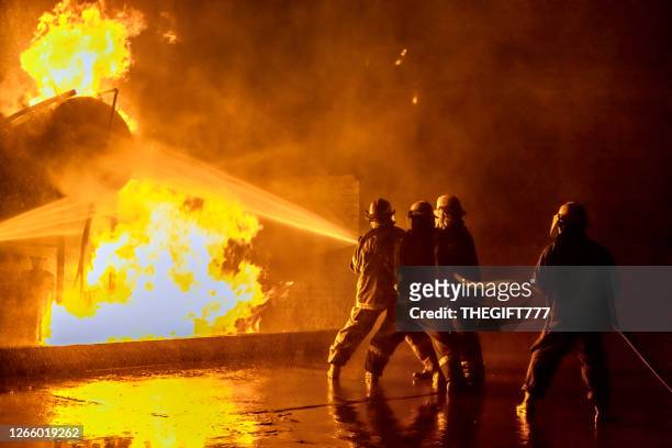 bomberos extinguiendo un incendio industrial - emergencies and disasters fotografías e imágenes de stock