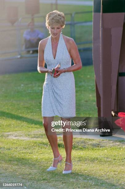 British Royal Diana, Princess of Wales , wearing a pale blue halter-neck dress by fashion designer Catherine Walker, as she attends a dinner hosted...