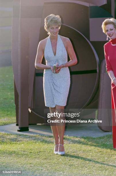 British Royal Diana, Princess of Wales , wearing a pale blue halter-neck dress by fashion designer Catherine Walker, as she attends a dinner hosted...