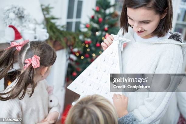 cute children enjoying christmas at home - child with advent calendar stock pictures, royalty-free photos & images