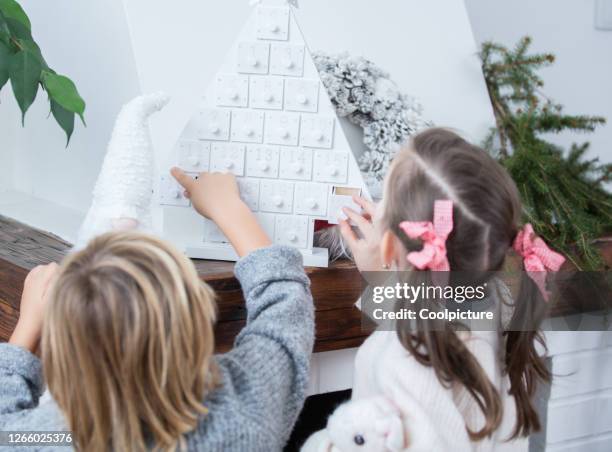 cute children enjoying christmas at home - child with advent calendar 個照片及圖片檔