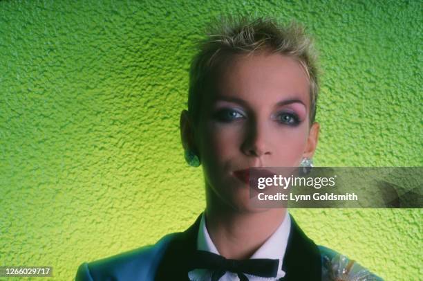 Studio portrait of British singer-songwriter Annie Lennox, of The Eurythmics, wearing a western bow tie, against a green background, 1984.
