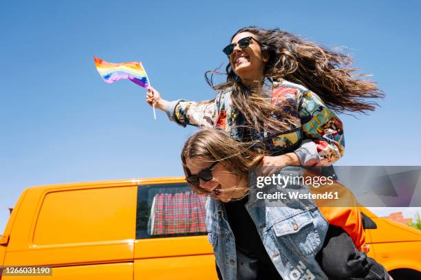 cheering lesbian couple having fun in front of van - soziale gerechtigkeit stock-fotos und bilder