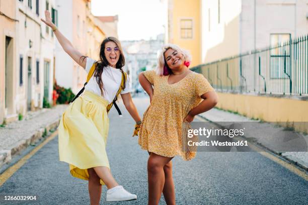 friends having fun while standing on road in city - chicas gorditas fotografías e imágenes de stock