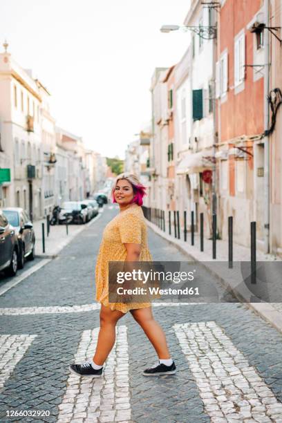 young body positive woman crossing street in city - chubby girls stockfoto's en -beelden