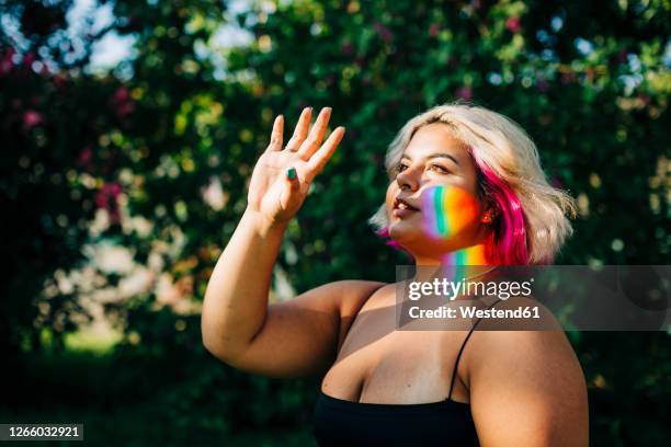 beautiful woman blocking light reflection with hand in park - beautiful fat women stock pictures, royalty-free photos & images