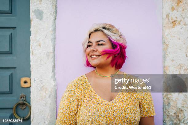 smiling plus size woman standing against wall - gefärbtes haar stock-fotos und bilder