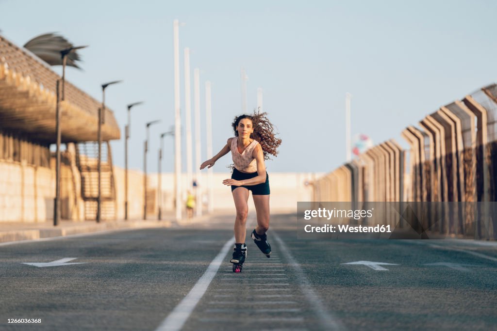 Young woman inline skating on boardwalk at the coast